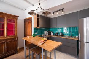 a kitchen with a wooden table and a refrigerator at Domus De Gorga - Your Sardinian Apartment in Cagliari