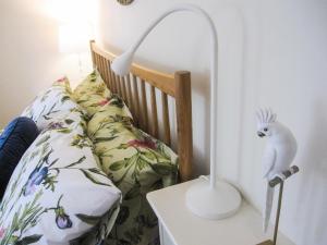uma lâmpada branca numa mesa ao lado de uma cama em Priory Place em Gloucester
