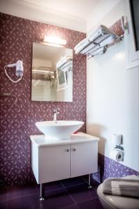 a bathroom with a sink and a mirror at Elektra Hotel in Paleros