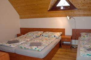 een slaapkamer met 2 bedden in een kamer met een plafond bij Chata Soukenná in Dolní Moravice