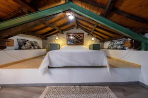 a bed in the middle of a room with wooden ceilings at Domus De Gorga - Your Sardinian Apartment in Cagliari