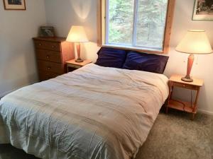 a bedroom with a large bed with two lamps on tables at Boulder Creek Cabin by Casago McCall - Donerightmanagement in Donnelly