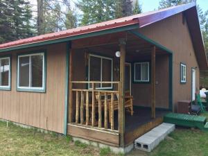 een tiny house met een veranda en een terras bij Boulder Creek Cabin by Casago McCall - Donerightmanagement in Donnelly
