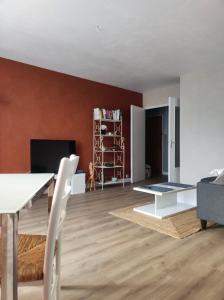 sala de estar con paredes rojas, mesa blanca y silla en L'appart, en Limoges