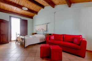 sala de estar con sofá rojo y cama en Sa Domo De Alene, en Bosa