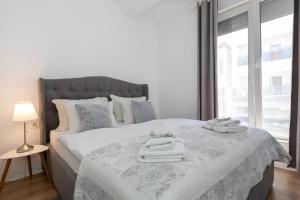 ein Schlafzimmer mit einem großen Bett mit Handtüchern darauf in der Unterkunft Happy Apartment II in Mostar