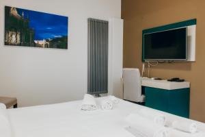 a hotel room with a desk and a tv at Guesthouse Lago di Nicito in Catania