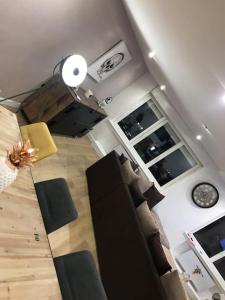 uma sala de estar com um sofá e um relógio na parede em Très belle appartement plein centre ville em Tourcoing