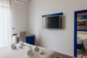 Habitación con TV y cama con toallas. en Guesthouse Lago di Nicito, en Catania