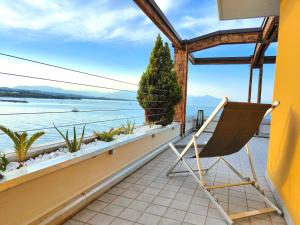 a chair on a balcony with a view of the water at TRA CIELO E LAGO - Gerale H&B (CIR017067-CIM-00420) in Desenzano del Garda