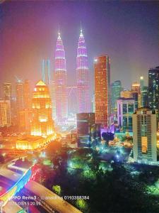 a city skyline with tall skyscrapers at night at Legasi Kampung baru guest house by rumahrehat 1908sqft huge balcony for BBQ twin tower view in Kuala Lumpur