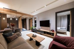 - un salon avec un canapé et une télévision dans l'établissement Woodside Residence 325, à Kopaonik