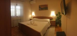 1 dormitorio con 1 cama con toallas en Holiday home Sandra, en Korčula