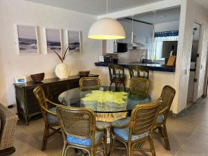 a dining room with a glass table and chairs at Casa Romantica De Playa in Ixtapa