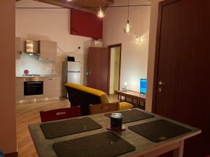 eine Küche und ein Wohnzimmer mit einem Tisch und einem Esszimmer in der Unterkunft Civico16 Appartamento in LʼAquila