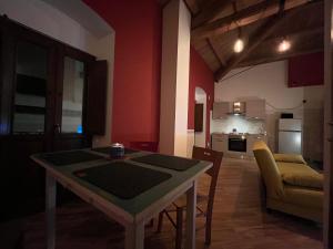 ein Wohnzimmer mit einem Tisch und einer Küche in der Unterkunft Civico16 Appartamento in LʼAquila