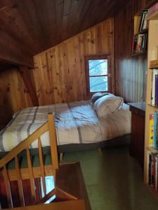 1 dormitorio con 1 cama en una cabaña de madera en Chalet accueillant et familial, en Saint-Martin-Vésubie