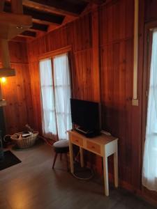 a room with a desk with a television on it at Chalet accueillant et familial in Saint-Martin-Vésubie