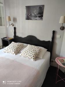 a bedroom with a bed with two pillows on it at Hôtel Verlaine in Paris