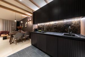 - une cuisine avec des placards noirs, un évier et une table dans l'établissement Woodside Residence 325, à Kopaonik