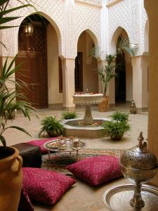 a room with a table, chairs, and a vase of flowers at Riad Kniza in Marrakech