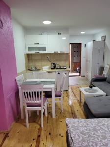 Il comprend une cuisine et un salon avec une table et des chaises. dans l'établissement Apartmani Lotos, à Kaluđerske Bare