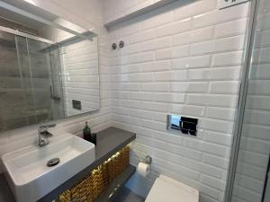 a white bathroom with a sink and a mirror at Simply Yellow Apartment in Lisbon