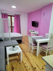 - un salon avec un canapé, une table et des chaises dans l'établissement Apartmani Lotos, à Kaluđerske Bare