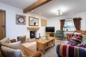uma sala de estar com mobiliário e uma lareira em Pinewood Cottage - Newby Bridge em Lake Side