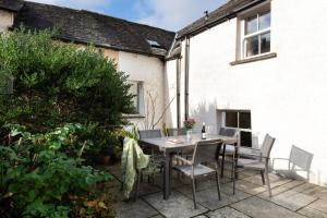 a table and chairs on a patio outside a house at Pinewood Cottage - Newby Bridge in Lake Side