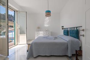 a white bedroom with a bed and a large window at Solemar Sicilia - Casa Margherita in Santa Flavia