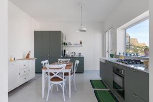 Una cocina con una mesa y sillas en una cocina. en Solemar Sicilia - Casa Margherita, en Santa Flavia