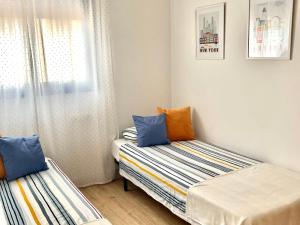 トレモリノスにあるPiso céntrico en Torremolinosのベッド2台と窓が備わる小さな客室です。