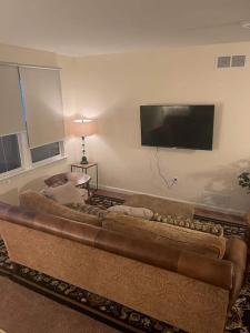 a brown couch in a living room with a flat screen tv at Entire Private 2 bedrooms house, nice neighborhood in Arnold