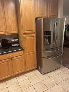 a kitchen with a stainless steel refrigerator and wooden cabinets at Entire Private 2 bedrooms house, nice neighborhood in Arnold