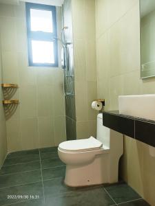 a bathroom with a toilet and a sink and a window at Legasi Kampung baru guest house by rumahrehat 1908sqft huge balcony for BBQ twin tower view in Kuala Lumpur