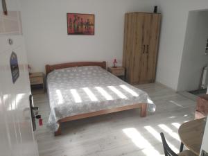 ザイェチャルにあるAPARTMAN “POD KRALJEVICOM”のベッドルーム1室(ベッド1台付)、木製キャビネットが備わります。