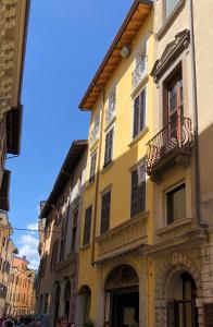 a yellow building with a balcony on a street at Casa Collini Salò in Salò
