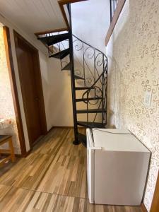 a room with a spiral staircase and a stair case at RESIDENCIAL BORGES CANELA in Canela