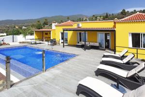 a villa with a swimming pool and a yellow house at Casa Diamante in Tijarafe