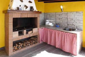 a kitchen with a brick fireplace and a sink at Casa Diamante in Tijarafe
