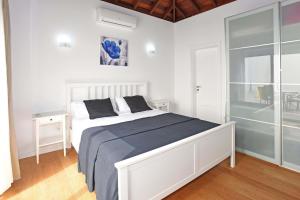 Un dormitorio blanco con una cama y una puerta de cristal. en Casa Diamante, en Tijarafe 19 fotos más