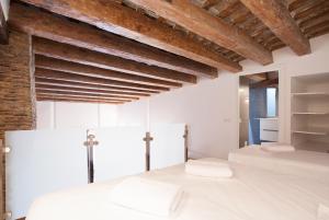 two beds in a white room with wooden ceilings at Habitat Apartments Alissia in Barcelona