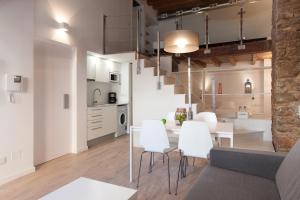 a living room and kitchen with a table and white chairs at Habitat Apartments Alissia in Barcelona