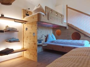 a bedroom with a wooden bunk bed with a staircase at SchartnerAlm in Collalbo