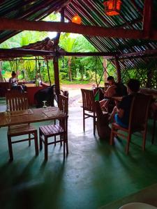 a group of people sitting at tables in a restaurant at Green View Safari Resort in Udawalawe