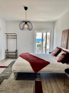 a white bedroom with a large bed and a window at Paraíso do Sítio 2 in Nazaré