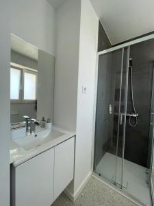 a white bathroom with a shower and a sink at Paraíso do Sítio 2 in Nazaré