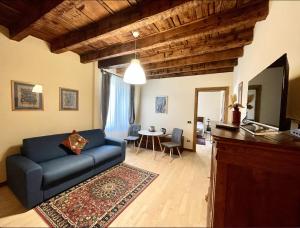salon z niebieską kanapą i stołem w obiekcie Casa Collini Salò w mieście Salò