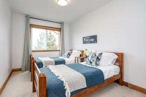 two beds in a room with a window at The Parker House Gorgeous Light and Spacious Chalet 86100 in Blue Mountains